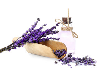 Bottle of lavender essential oil and scoop with flowers on white background