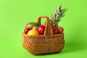 Fototapeta na wymiar Basket with fresh fruits on color background