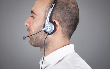 Caucasian customer support operator with headset in office.
