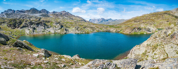 Fototapeta na wymiar Idyllic blue alpine lake high up on the mountains, scenic landscape rocky terrain at high altitude on the Alps, panoramic view