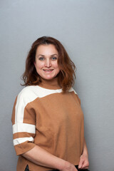Emotional, pretty woman of 45 years old smiling on   gray background .