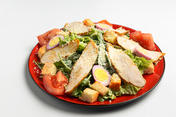 Caesar Salad made of chicken meat, tomatoes, eggs, fresh arugula, croutons, cheese and sauce on top.