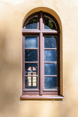 Arched window on a plastered painted wall