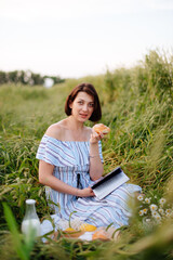 Naklejka na ściany i meble Beautiful young woman in summer in a wheat field