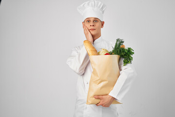 cheerful male chef with a package of products working in the kitchen