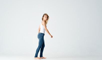 Fototapeta na wymiar cheerful woman woman in jeans barefoot dancing on the floor