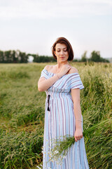 Beautiful young woman in summer in a wheat field