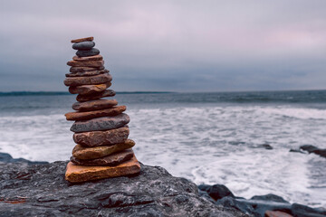 Fototapeta premium Pyramid of stones by the ocean at blue hour