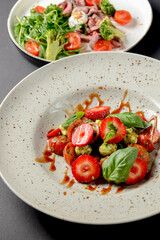 Caprese salad with strawberries. Salad with mozzarella, tomatoes, basil and strawberries.