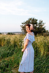 Beautiful young woman in summer in a wheat field