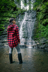 young hiking woman looking at waterfall