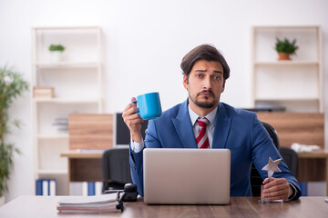 Young male employee with star award at workplace