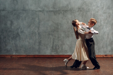 Young boy and girl dancing in ballroom dance Viennese Waltz.