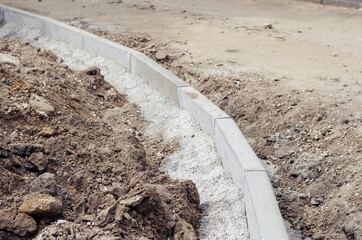 Installation of new curbs. The gray curbs are fixed in cement mo