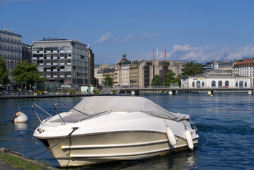 Fototapeta na wymiar White motor boat with buoy in the background at City of Geneva on a sunny summer day. Photo taken July 29th, 2021, Geneva, Switzerland.