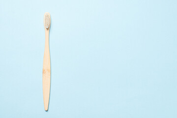 Bamboo toothbrush on a blue background.