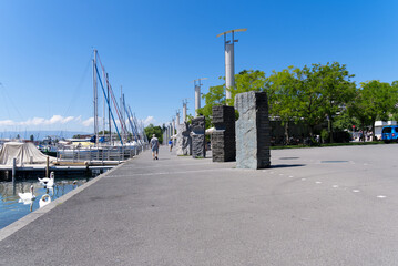 Fototapeta na wymiar Port with sailing yachts at Lausanne Ouchy at a beautiful summer morning wich cloudy blue sky background. Photo taken July 29th, 2021, Lausanne, Switzerland.