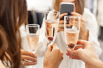 Beautiful female hands are holding glasses of champagne or rose wine. Close-up. Women clink glasses. New Years celebration, event or party. Soft focus. Human hands.