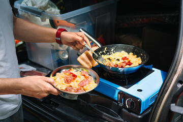 Person cooking omelet on camping stove