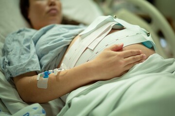 A pregnant woman being induced in the hospital, with iv and contractions monitor. - obrazy, fototapety, plakaty