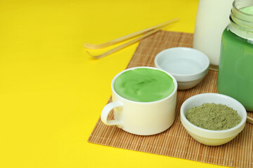 Obraz na płótnie Canvas Matcha latte and accessories for making on yellow background