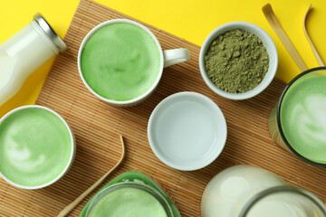 Matcha latte and accessories for making on yellow background