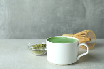 Matcha latte and accessories for making on white textured table