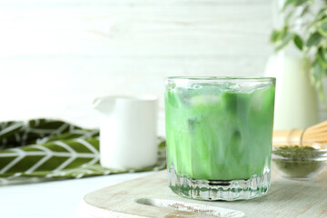 Matcha latte and accessories for making on white wooden table