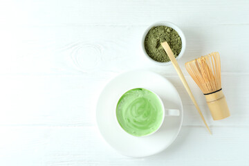 Matcha latte and accessories for making on white wooden table
