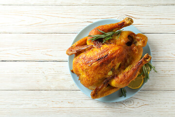 Plate with roast turkey on white wooden table