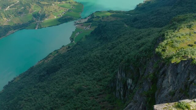 Lush Forest Trees Downhill Of Klovane Summit Near Olden Village In Norway. - Aerial Pullback Shot