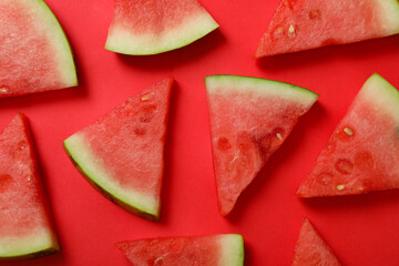 Ripe juicy watermelon slices on red background