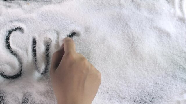 Human / female hands writing the word "SUGAR" with the help of letters and alphabets. Powdered sugar scattered against a black background - baking  excess sugar  creative ideas  unhealthy lifestyle