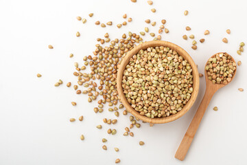 Buckwheat in wooden bowl on white background