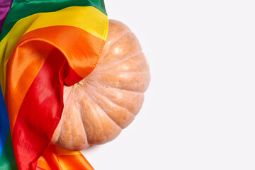 LGBTQ rainbow flag and big orange pumpkin. Halloween pumpkin with rainbow LGBT flag