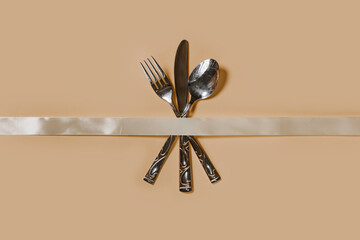 A set of cutlery - fork, spoon and knife. Top view. Pastel background