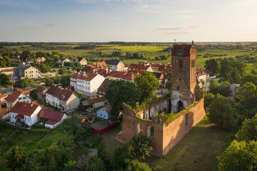 Fototapeta na wymiar Aerial: The restored facades of the Zheleznodorozhny town on the background of an abandoned old Prussian church