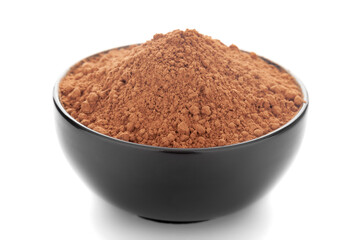 Close-up of organic  powder of cocoa seed (Theobroma cacao)  in a black ceramic bowl over white background.