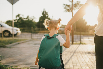 Cute little schoolgirl with school bag on a street