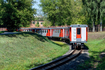 Naklejka premium The train departs around the bend. Russian children's railway in Novomoskovsk in August 2021.