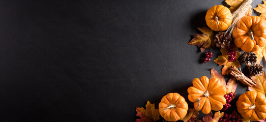 Autumn background decoration from dry leaves and pumpkin on dark wooden background. Flat lay, top...