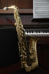 Beautiful saxophone near grand piano. Musical instruments