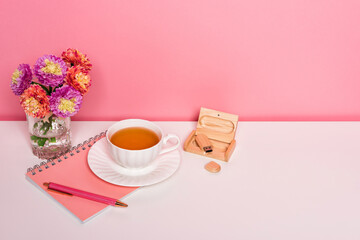Home office workspace with a flowers cup of tea on white table