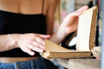 Close-up of woman's hands with book, bookstore. Education, school, study, reading fiction concept.