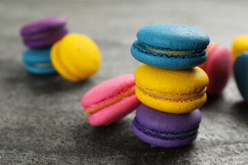 Fototapeta na wymiar Delicious colorful macarons on grey table, closeup
