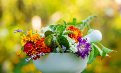Medicinal herbs and flowers in a mortar. Selective focus.