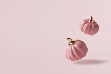 Two levitating pink decorative pumpkins on light pink background with copy space. - 451375855