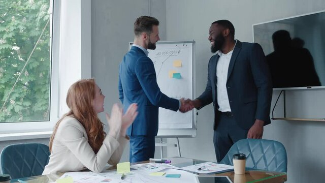 The boss congratulates the employee for a good performance, a new business strategy. Handshake of two businessmen in the meeting room
