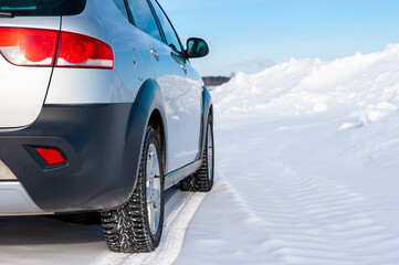 A modern SUV stopped on the side of a winter road in the woods. The concept of a family trip to nature. Winter or spring break, adventure. Skiing.