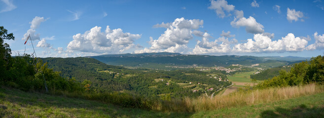 Panorama shot of the city of Buzet in Istria with green mountains, blue sky and white clouds